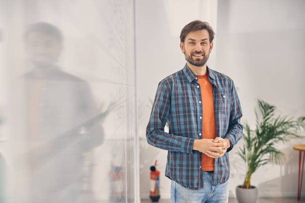 istock Cheerful young man standing in modern office 1260696115