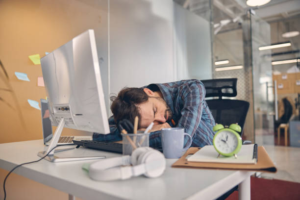istock Exhausted overworked young man taking nap in office 1260696138