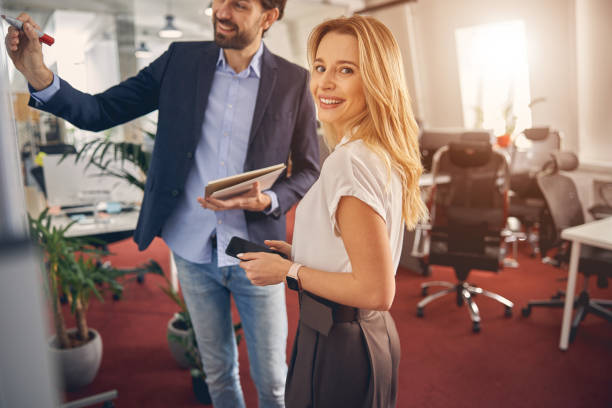 istock Cheerful young woman working with colleague in office 1260699749