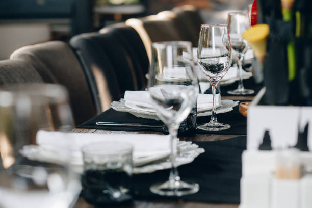 istock tableware Glasses, flower fork, knife served for dinner in restaurant with cozy interior 1260712726