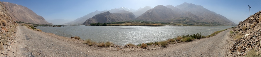 Panj river and hindukush mountains panoramic view. Panj is upper part of Amu Darya river. Tajikistan and Afghanistan border. Pamir highway