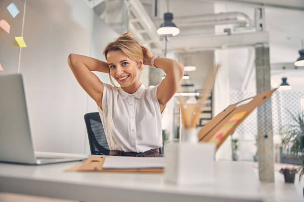 istock Joyful young woman sitting at the table with laptop at work 1260733024