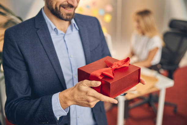 istock Young man holding red gift box with elegant ribbon 1260734121