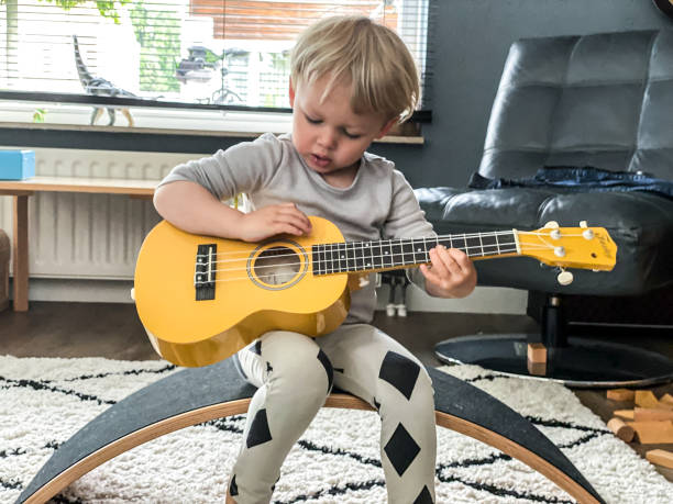 istock Toddler boy playing his toy guitar 1260775496