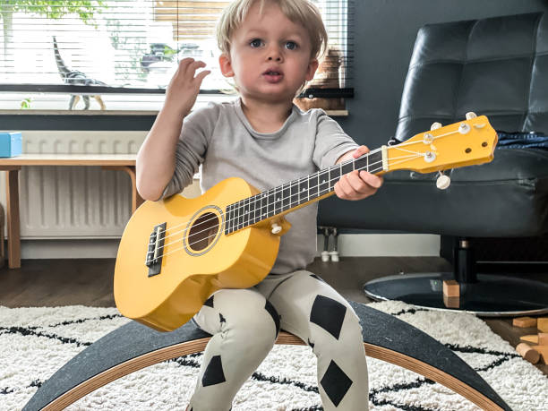 istock Toddler boy playing his toy guitar 1260775506