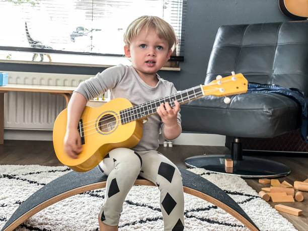 istock Toddler boy playing his toy guitar 1260776529