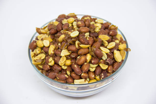 istock Roasted peanuts in glass bowl on white background 1260790830