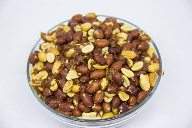 istock Roasted peanuts in glass bowl on white background 1260793957