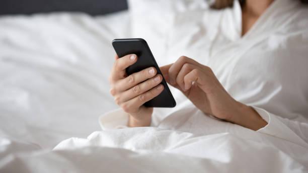 istock Woman lying in bed with smartphone checking social networks messages 1260812021