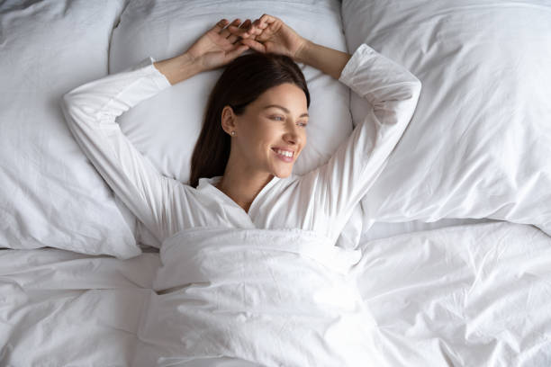 istock Woman lying alone in comfortable bed after night sleep 1260812537