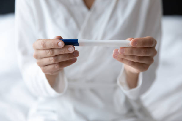 istock Closeup image female hands holding positive negative result pregnancy test 1260812564