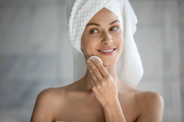 donna che tiene il batuffolo di cotone utilizza gel detergente bifasico rimuovendo il trucco - acqua tonica foto e immagini stock