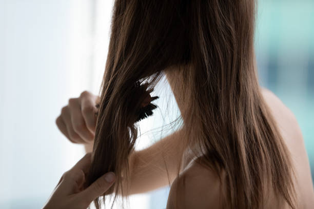 крупным планом заднего вида женщина расчесывать волосы делать утреннюю рутину - natural bristle стоковые фото и изображения