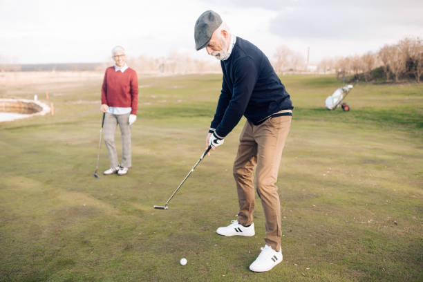 istock Senior man playing golf with his wife 1260814192
