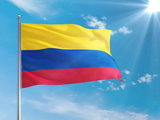 Photo of Colombia national flag waving in the wind against deep blue sky. High quality fabric. International relations concept.