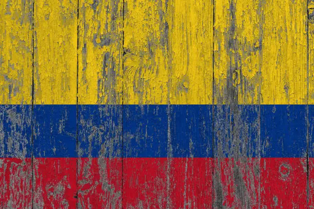 Photo of Colombia flag on grunge scratched wooden surface. National vintage background. Old wooden table scratched flag surface.