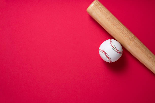 istock baseball and baseball bat on red table background, close up 1260829641