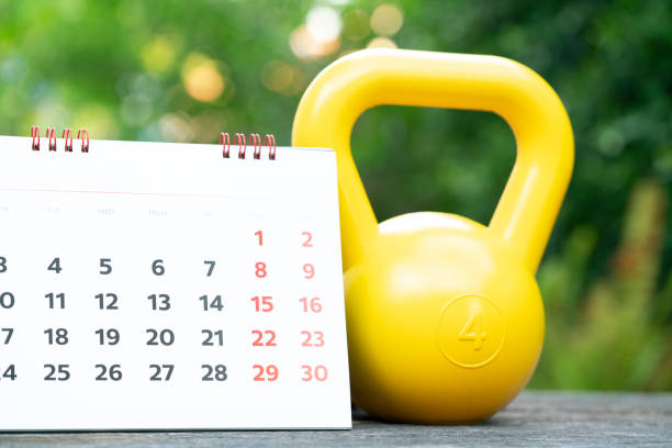 istock Time for exercising calendar and kettlebell sport equipment on the table background 1260831776