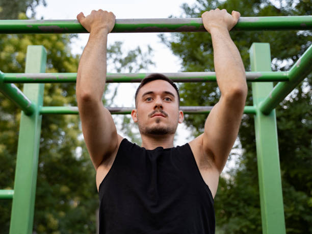istock Young handsome man doing pull ups in the park , street workout 1260836432