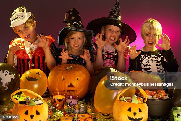 Photo libre de droit de La Fête Dhalloween Avec Des Enfants En Costumes banque d'images et plus d'images libres de droit de Citrouille - Citrouille, Confiserie - Mets sucré, Costume de déguisement