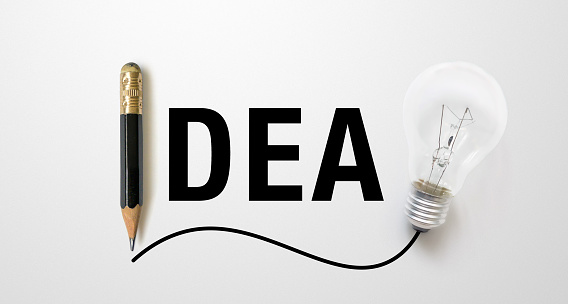 Black colour pencil with outline to end point and light bulb with word meaning IDEA on white paper background. Creativity inspiration ideas concept