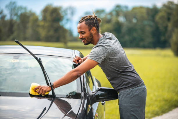 istock Mixed Race Man Washing the Car in the Backyard 1260928878