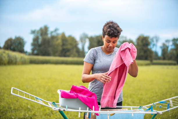 Young Mixed Raced Woman Hanging Laundry In The Backyard