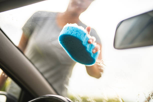 A wet microfiber cloth is left on the windshield of the car