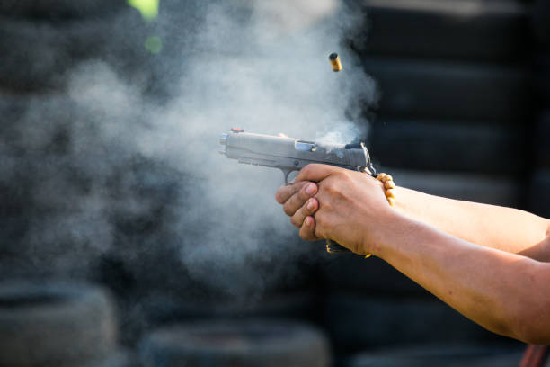 sparare da una pistola. ricaricare la pistola. l'uomo punta al bersaglio - handgun foto e immagini stock