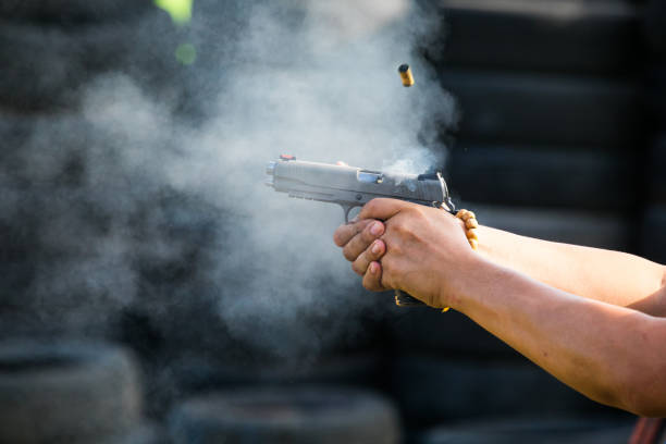 shooting from a pistol. reloading the gun. the man is aiming at the target - handgun imagens e fotografias de stock