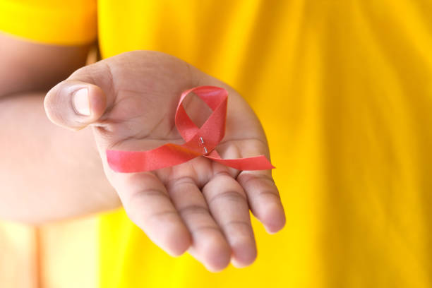 istock hand holding red HIV ribbon with copy space 1260975577