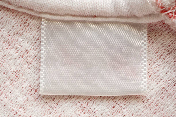 istock White blank laundry care clothes label on cotton shirt background 1260985035