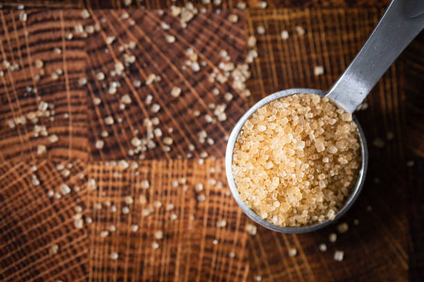 Turbinado sugar on a teaspoon measuring spoon.
