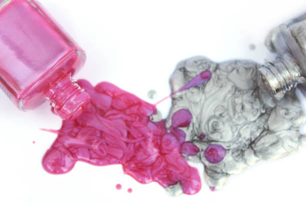 istock Pink and Silver Nail polish Spilled on White 1261049662