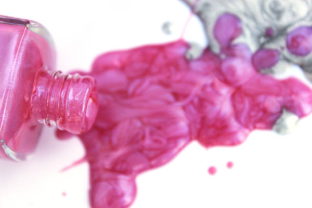 istock Pink and Silver Nail polish Spilled on White 1261049668