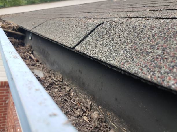 istock dirty metal gutter with roof shingles on house 1261050567