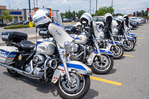 Ottawa, ON, Canada - July 3, 2020: A row of five parked Harley-Davidson motorcycles used by the Ottawa Police in a Barrhaven plaza parking lot.