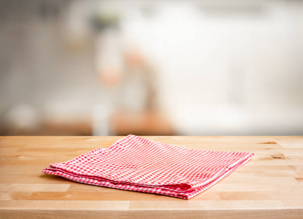 istock Red fabric,cloth on wood table top on blur kitchen counter (room)background 1261081750
