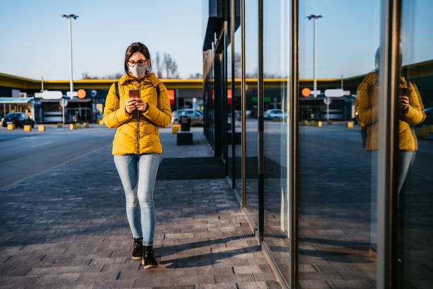 istock Woman in shopping mall with face mask using phone 1261093254