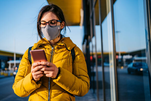 istock Woman in shopping mall with face mask using phone 1261093773