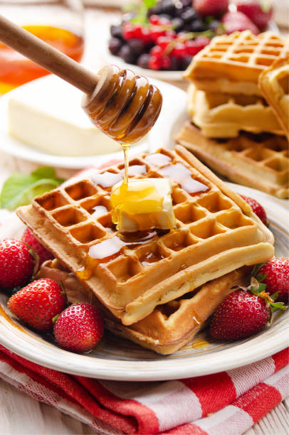 istock Belgian waffles served with butter strawberries and honey 1261099668