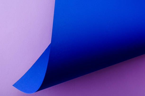 istock curved blue paper on violet background 1261100217