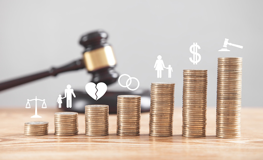 Judge gavel, coins and divorce symbols on the desk.