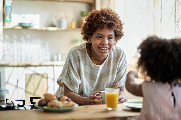 istock Afro-Caribbean Mother Interacting With Daughter at Breakfast 1261144895