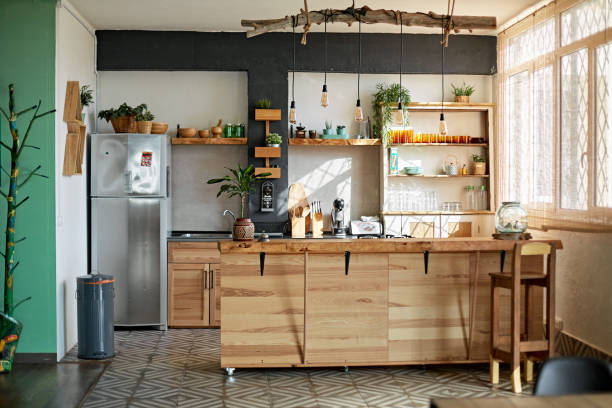 Apartment Kitchen in Modern Rustic Style Wide angle view of unoccupied modern kitchen with rustic style including wooden kitchen island and hanging pendant lighting. kitchen island stock pictures, royalty-free photos & images