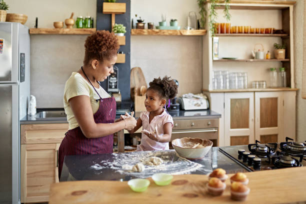 istock Afro-Caribbean Mother Teaching Young Daughter How to Bake 1261144920