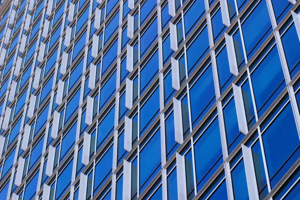 Repeating pattern of a large number of blue Windows.Facade of a modern office building.Exterior of a skyscraper.Urban architecture.Daylight illumination.The view from the bottom up.