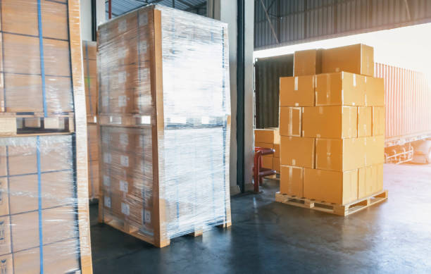 istock Stacked of shipment boxes on pallets waiting for load into container truck. Cargo freight export and import, Logistics and transportation. 1261169534