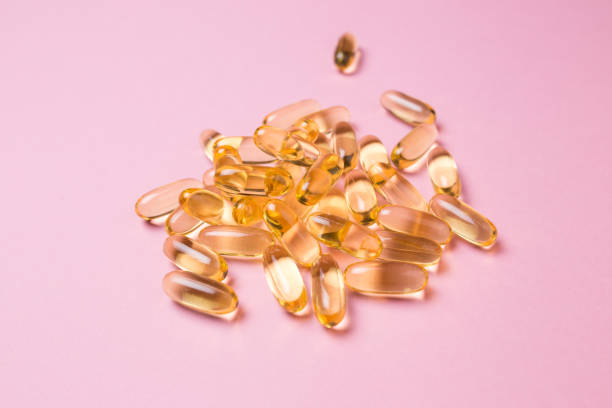 istock Close up vitamin C capsules on pink isolated background 1261173820