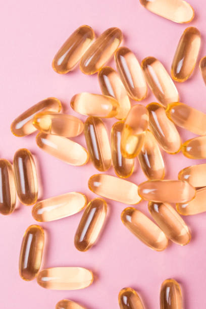 da vicino capsule di vitamina c su sfondo rosa isolato - gel capsules foto e immagini stock
